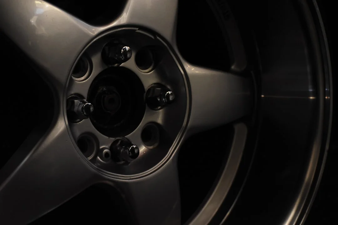 Close-up of a gleaming billet floater spinner wheel on a lowered custom car at a car show, chrome catching sunlight